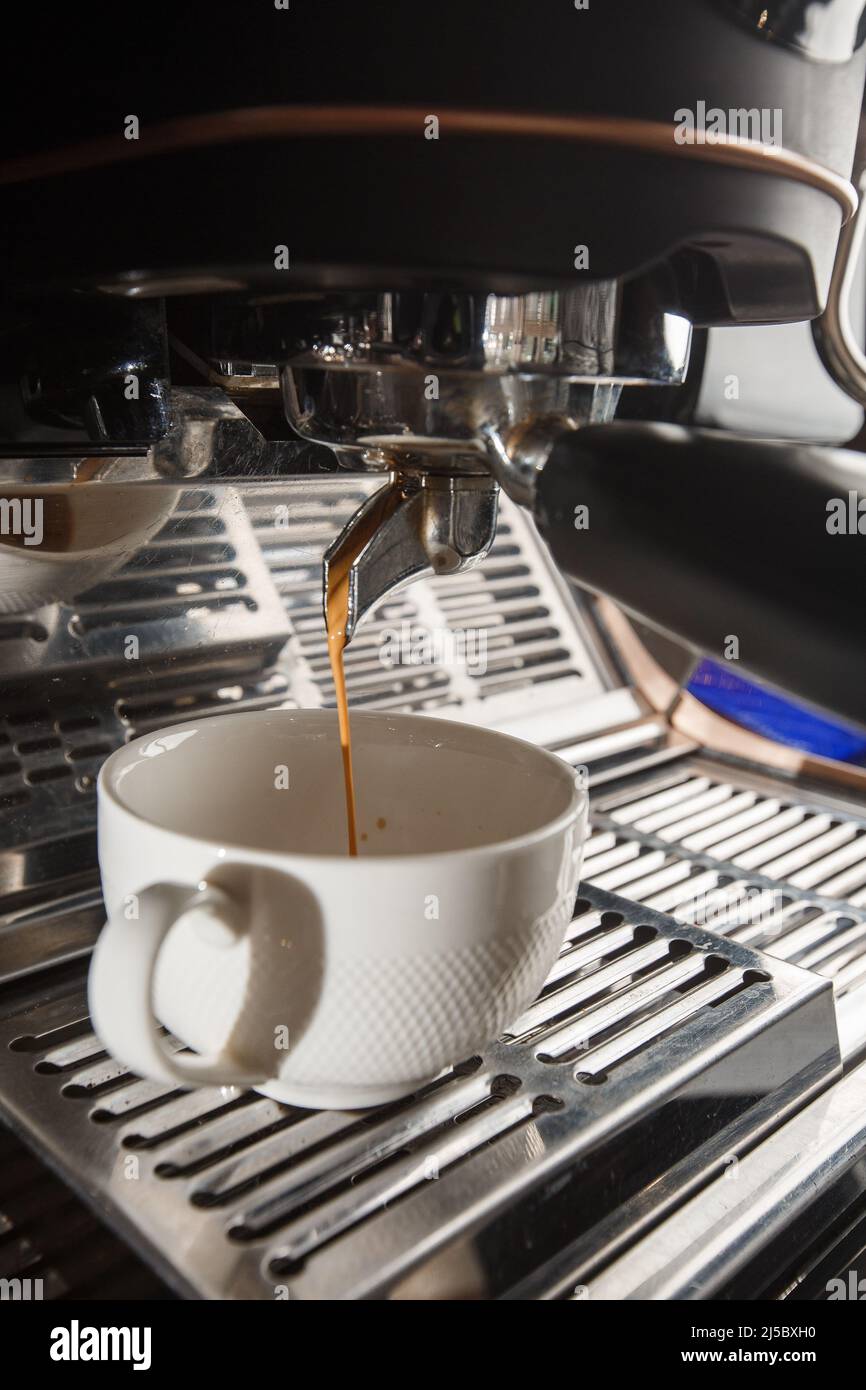 https://c8.alamy.com/compes/2j5bxh0/vierta-el-flujo-de-cafe-de-la-cafetera-profesional-en-una-taza-barista-que-hace-espresso-utilizando-el-portafiltro-cafe-recien-molido-bebiendo-bl-asado-2j5bxh0.jpg