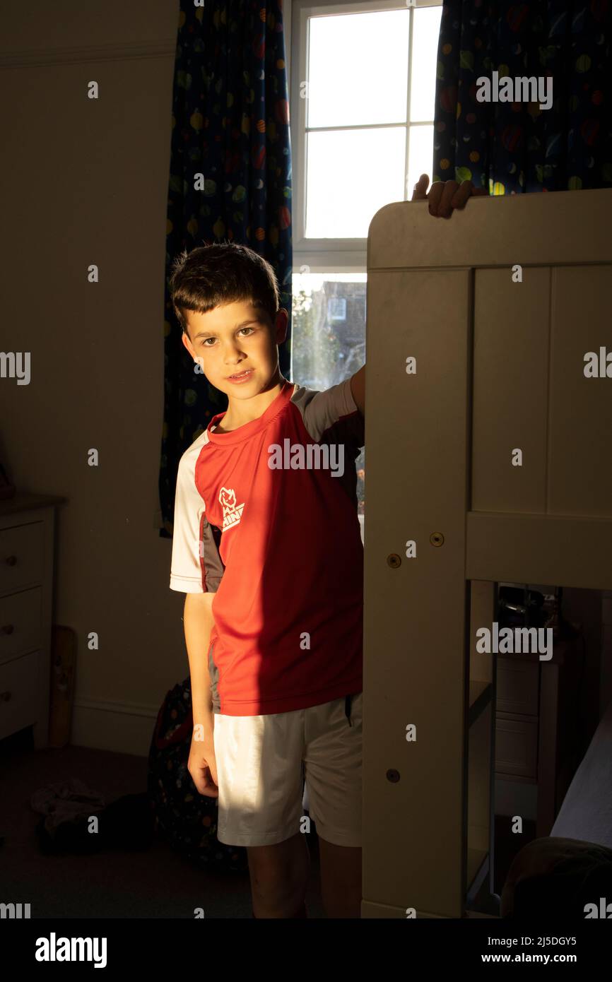 Niño de 8 años en su habitación mientras llevaba ropa deportiva,  Inglaterra, Reino Unido Fotografía de stock - Alamy