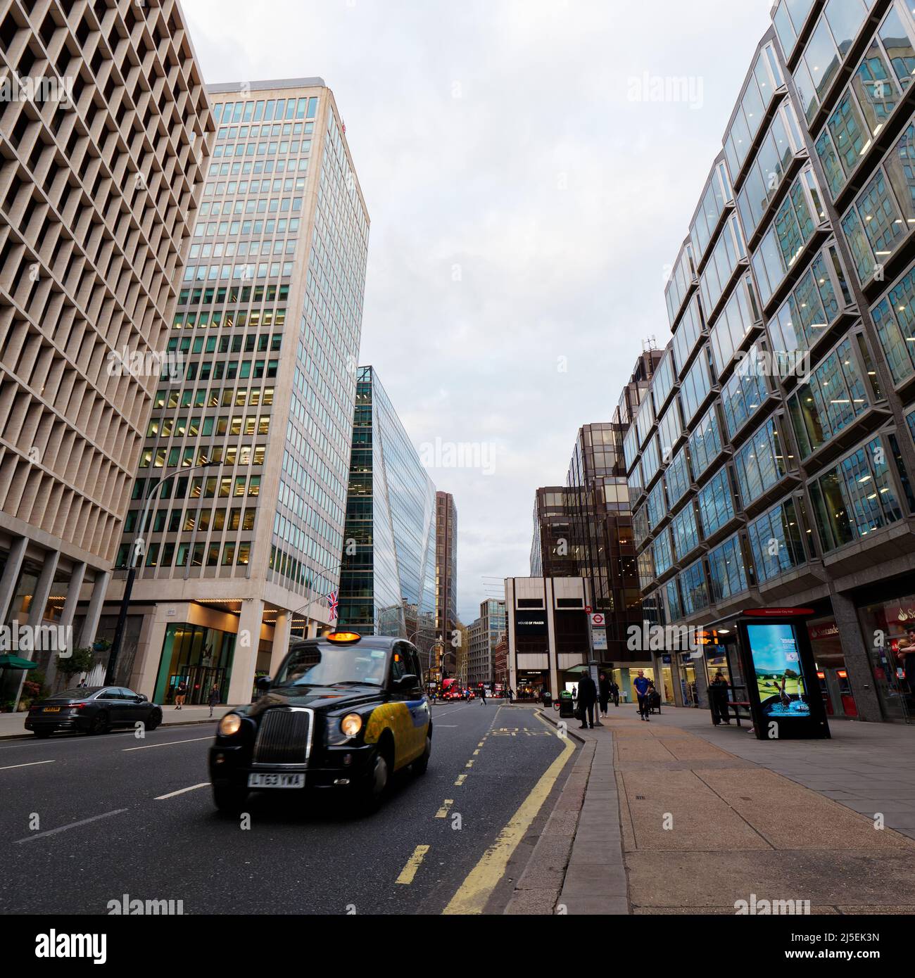Londres, Gran Londres, Inglaterra, 13 2022 de abril: Taxi con faros y parada de autobús en Victoria Street en Westminster por la noche. Foto de stock