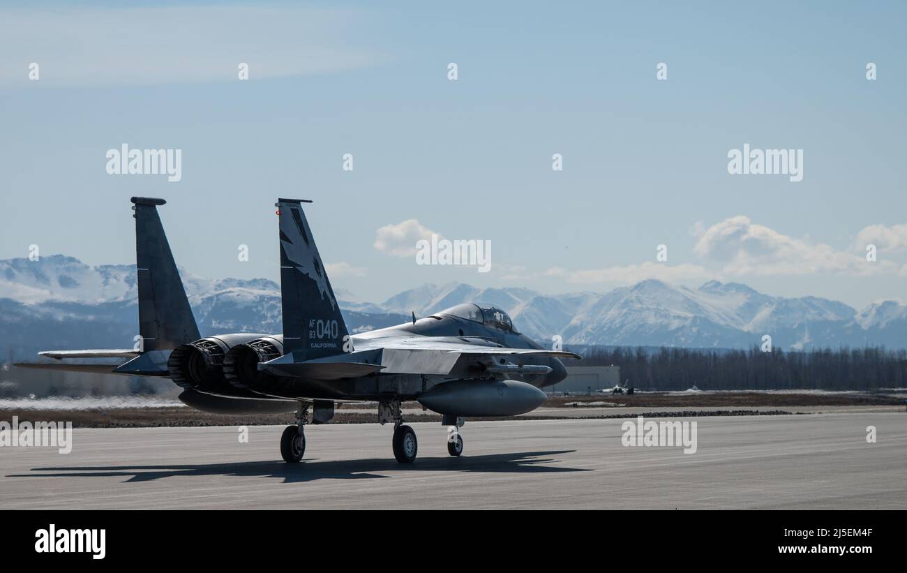 Un águila de la Fuerza Aérea de los Estados Unidos F-15 asignó a los 144th taxis del ala de combate de la Guardia Nacional Aérea de California por la línea de vuelo antes de una sortie en la Base Conjunta Elmendorf-Richardson, Alaska, el 18 de abril de 2022. Los Eagles se desplegaron en Alaska para mejorar la interoperabilidad con la misión de alerta del mundo real de JBER Raptor. (EE.UU Foto de la Fuerza Aérea de Airman 1st Clase Andrew Britten) Foto de stock