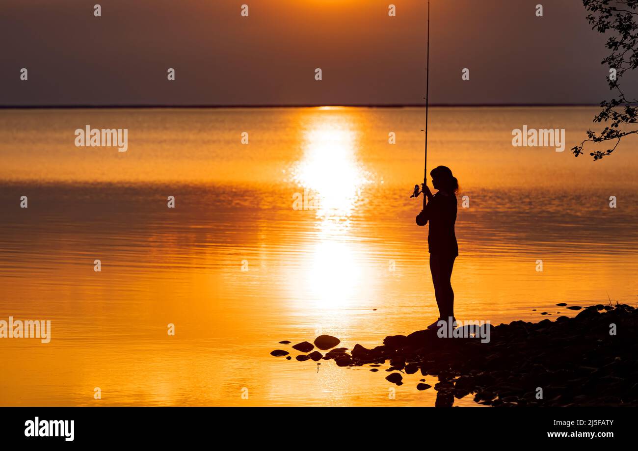 Mujer pesca en caña de pescar spinning en Finlandia Foto de stock