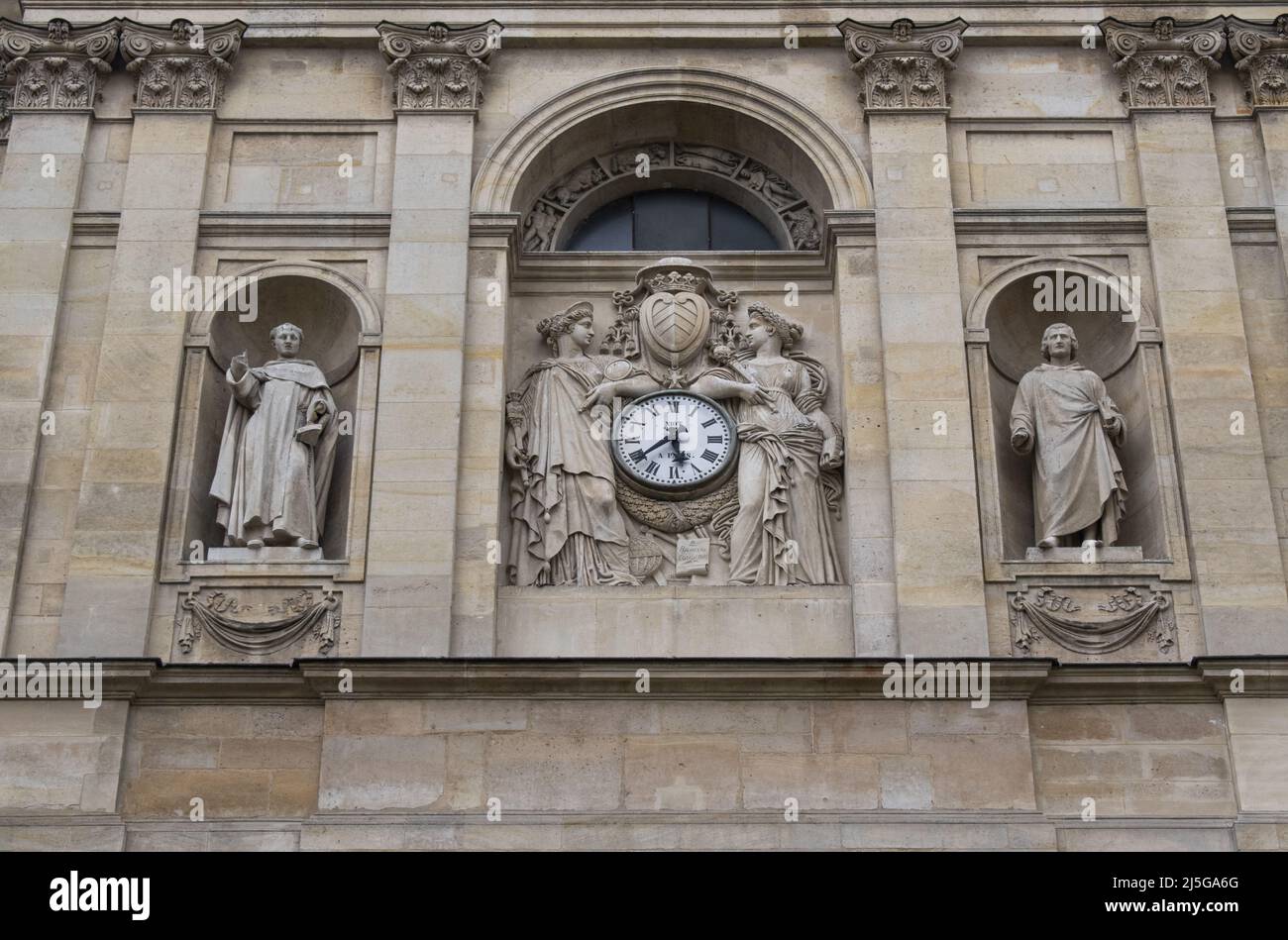 París, Francia reloj y estatuas en la fachada de la Capilla de la