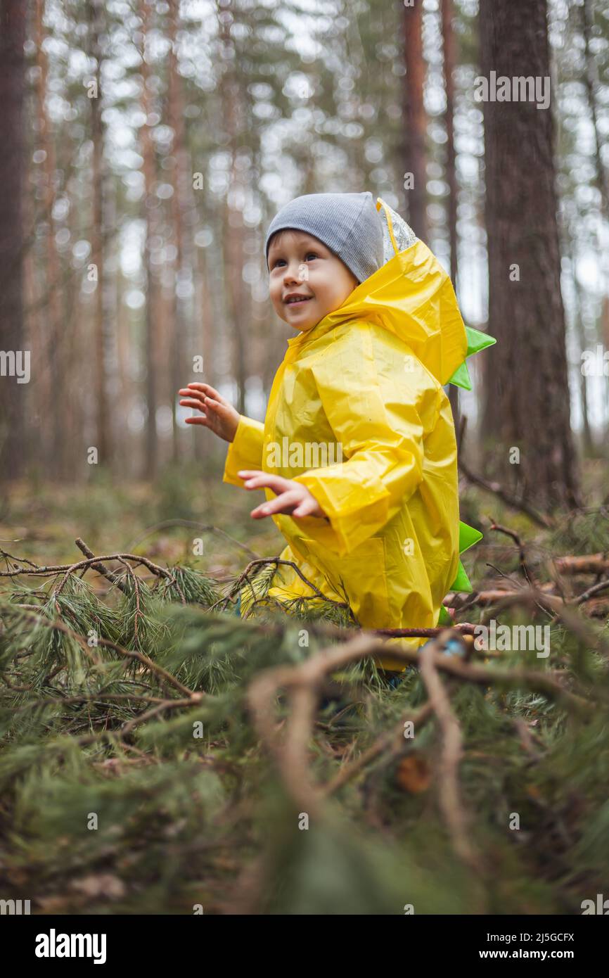 Niño en el chubasquero amarillo camina en el bosque después de la lluvia y  la diversión Fotografía de stock - Alamy