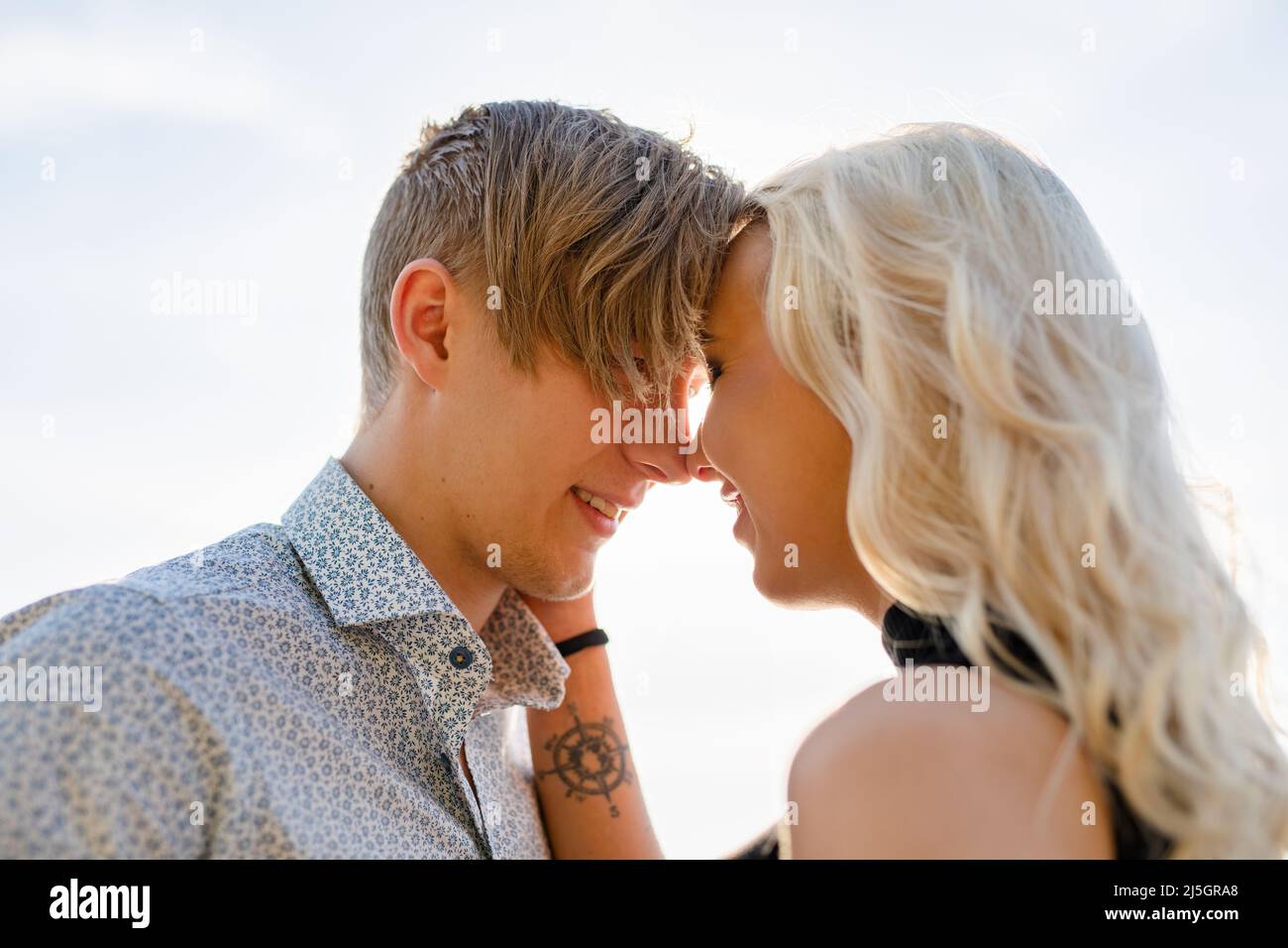 Pareja de novios en un romántico abrazo en la playa en verano Foto de stock