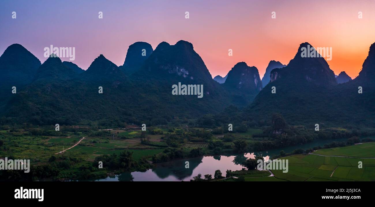 Vista aérea de verdes montañas y coloridas nubes al atardecer en Guilin, China. Foto de stock