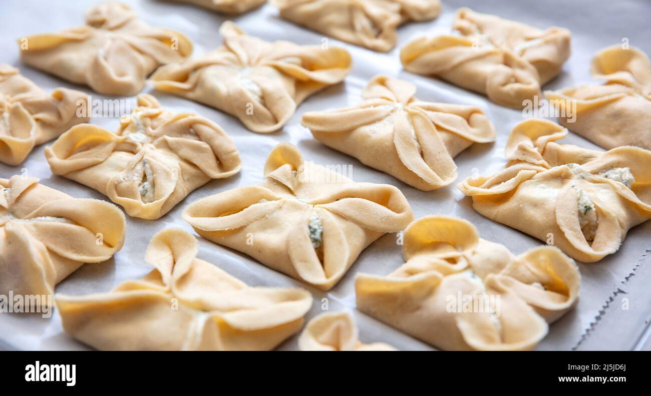 Kaltsounia Cretán pasteles caseros en la sartén del horno listo para hornear, vista de cerca. Kalitsounia tradicional Creta isla de Pascua, Grecia. Capricho de boda s Foto de stock