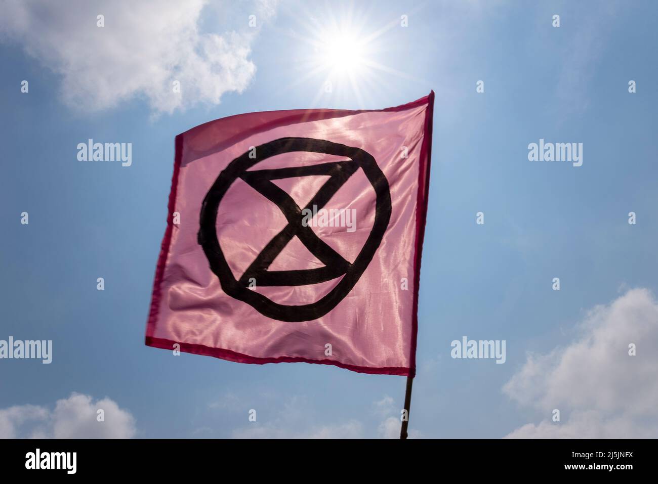 Extinción Bandera de Rebelión, con símbolo de reloj de arena, bajo un sol brillante. Calentamiento global, activismo por el cambio climático. Voló durante la protesta de aguas residuales en Southend Foto de stock