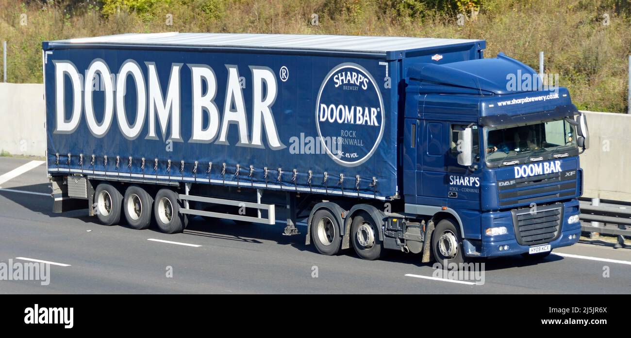 Frente y lado de Sharps Brewery negocio hgv entrega camión y gran marca Doombar publicidad Doom Bar cerveza en cortina lateral remolque autopista del Reino Unido Foto de stock