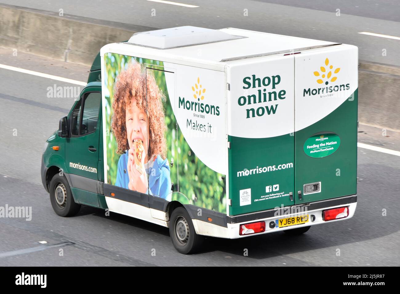 Parte trasera trasera y vista aérea del supermercado Morrisons en línea casa de compras de comida van con gráficos laterales conduciendo por la carretera de la autopista inglesa del Reino Unido Foto de stock