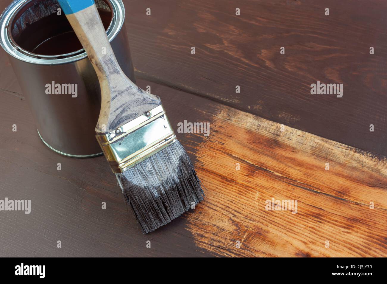 Pinte el cepillo y la lata de pintura sobre la superficie de madera Foto de stock