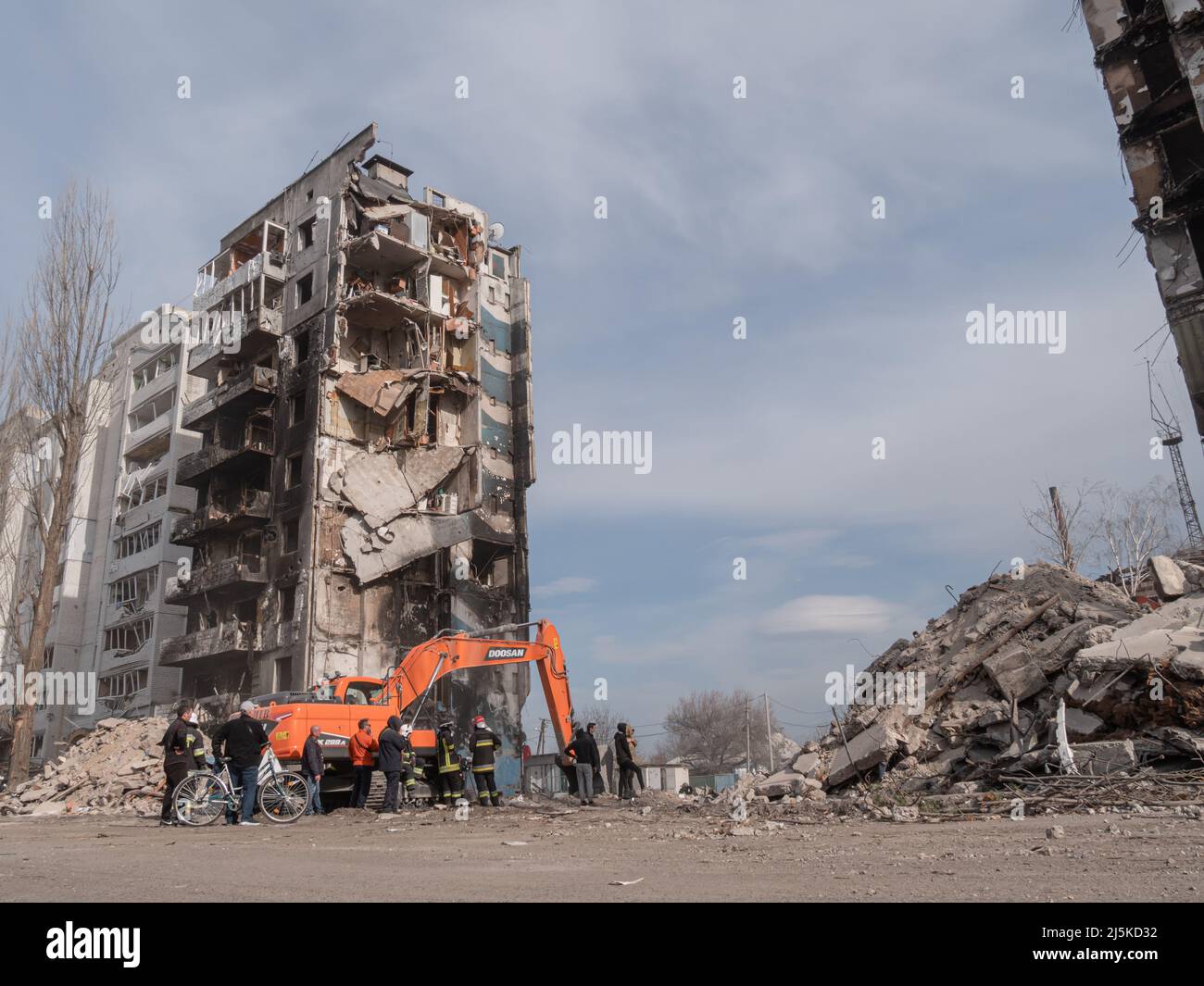 Borodyanka, Ucrania - 2022 de abril: Equipo de rescate está buscando personas muertas bajo los escombros. Búsqueda de obras de personas afectadas en las ruinas de un edificio de apartamentos. Casas bombardeadas de civiles en Ucrania Foto de stock