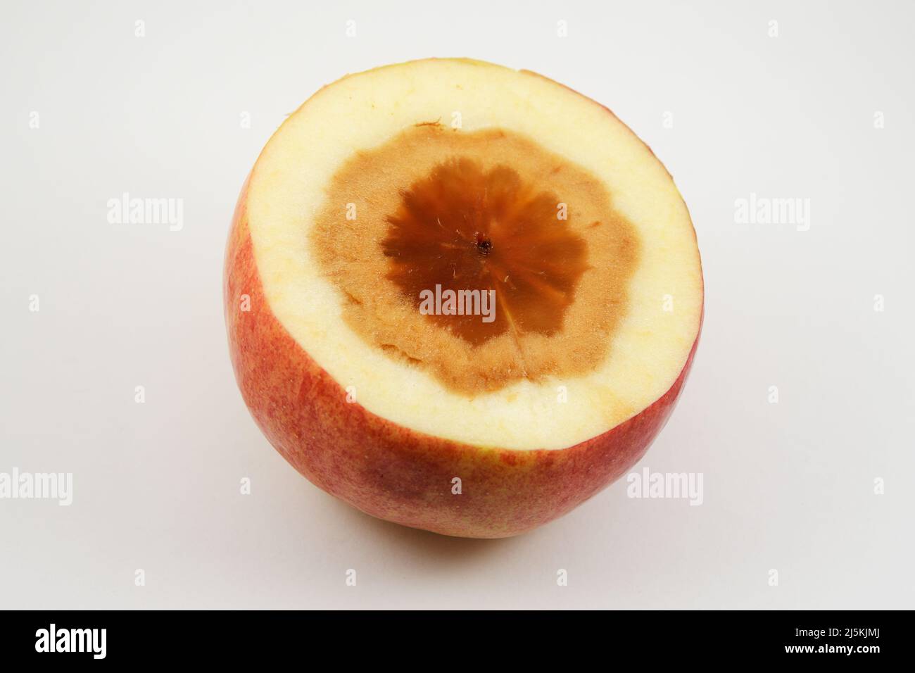 manzana cortada con núcleo podrido sobre fondo neutro Foto de stock