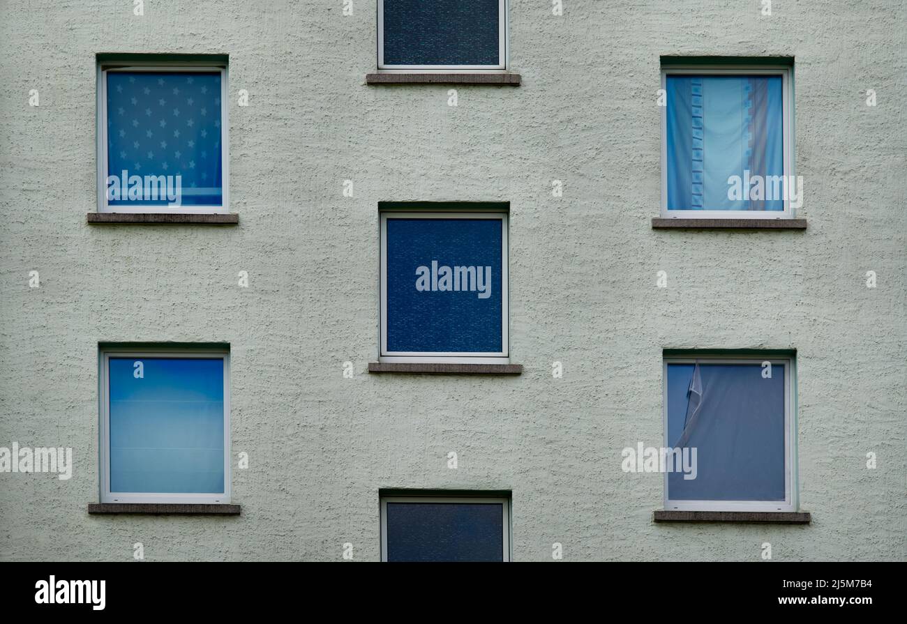sección de la fachada blanca de un edificio con cinco ventanas en tonos azules en un diseño perfectamente simétrico Foto de stock