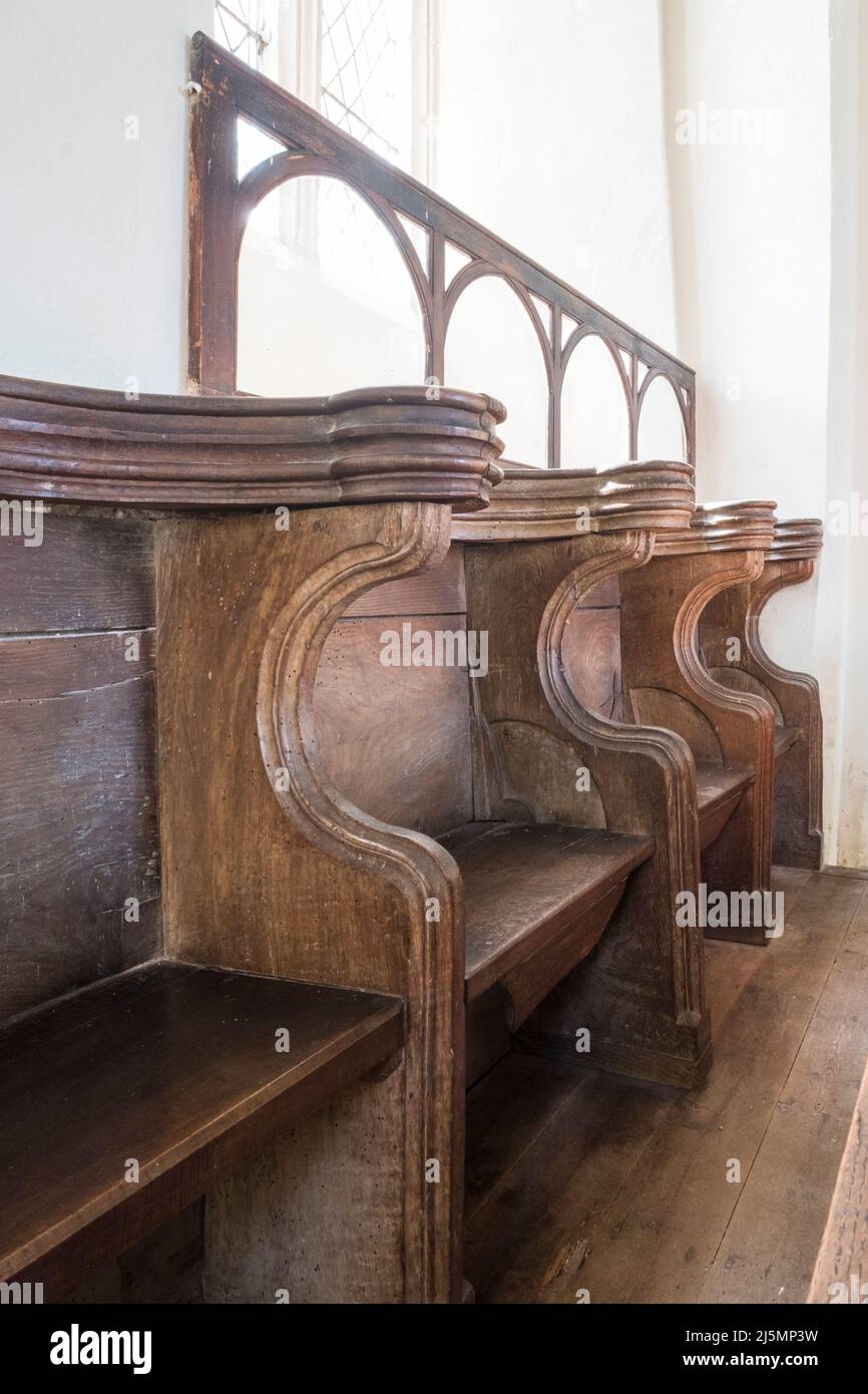Misericord tiene asientos en la iglesia San Juan Bautista, Denham, Suffolk, Reino Unido. Foto de stock