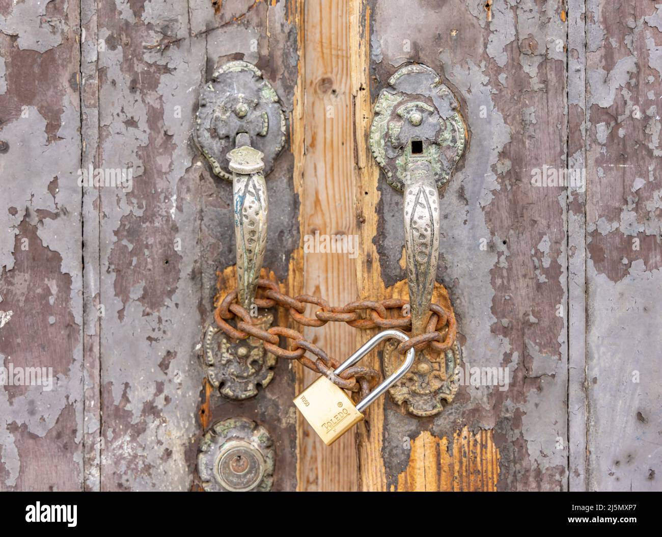 Detalle de una puerta antigua con un conjunto de tiradores de puerta de latón en el Viejo San Juan Foto de stock