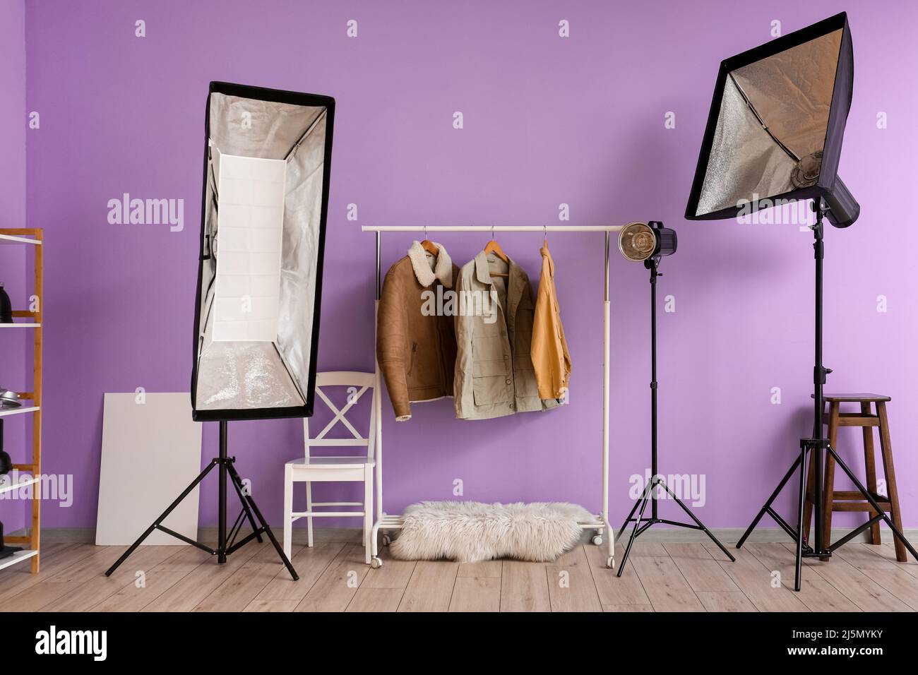 Tendedero con ropa y equipo de iluminación cerca de la pared lila en un  moderno estudio fotográfico Fotografía de stock - Alamy