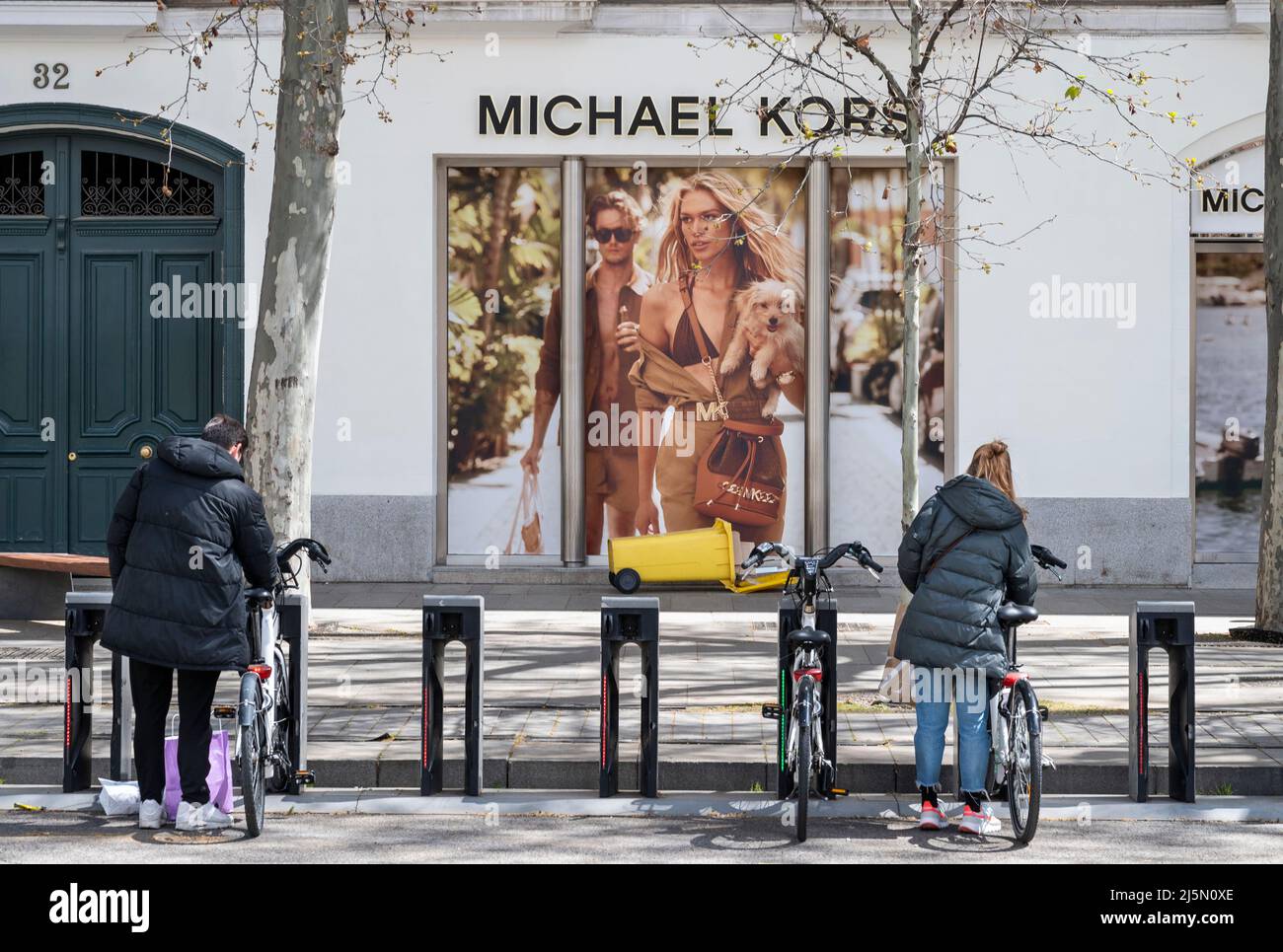 Madrid, España. 3rd de Abr de 2022. Los viajeros de transporte público  alquilan bicicletas frente a la tienda de moda de ropa americana Michael  Kors (MK) en Madrid, España. (Imagen de crédito: ©