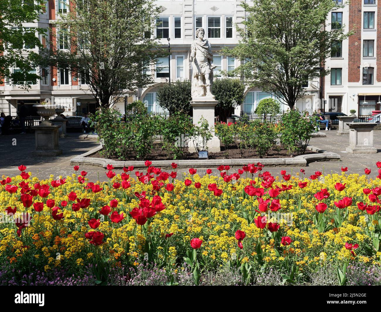 Una vista de la Plaza de Oro en Soho London UK en un soleado día de primavera con una cama de hermosas flores de primavera Foto de stock