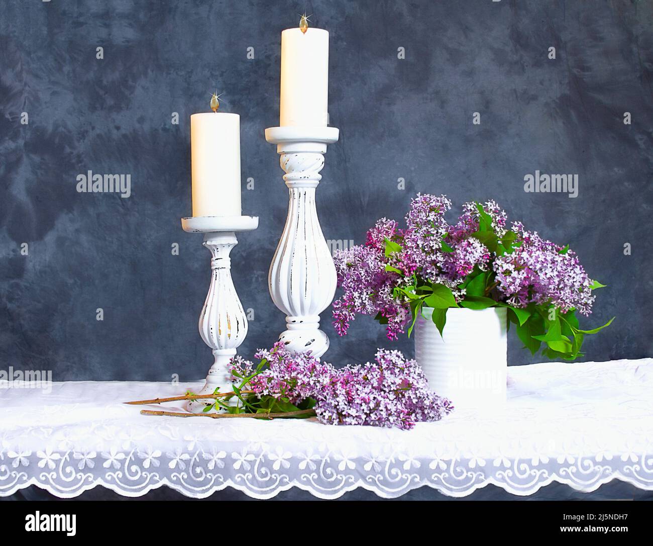 Dos pilares bonitos con velas y lilas moradas Fotografía de stock - Alamy