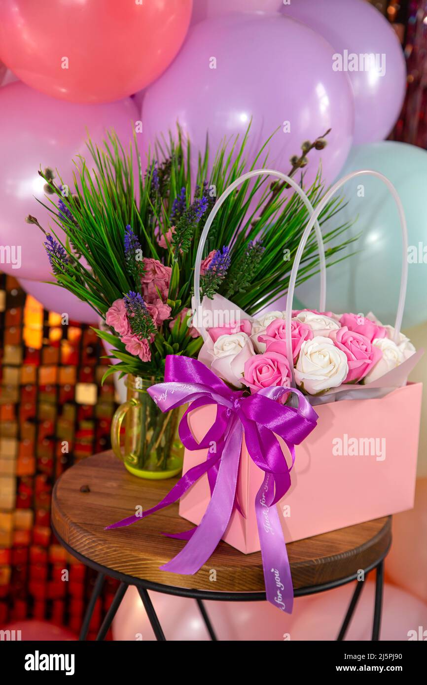 Fondo festivo de un ramo de rosas, verdor y globos de colores Fotografía de  stock - Alamy