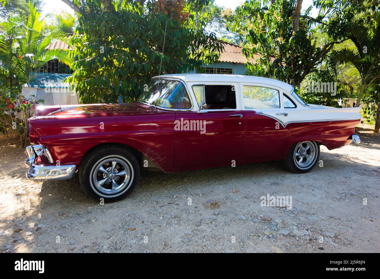 HOLGUÍN, CUBA - FEBRERO 2020: Clásico coche rojo y blanco en la pista con  árbol en el fondo Fotografía de stock - Alamy