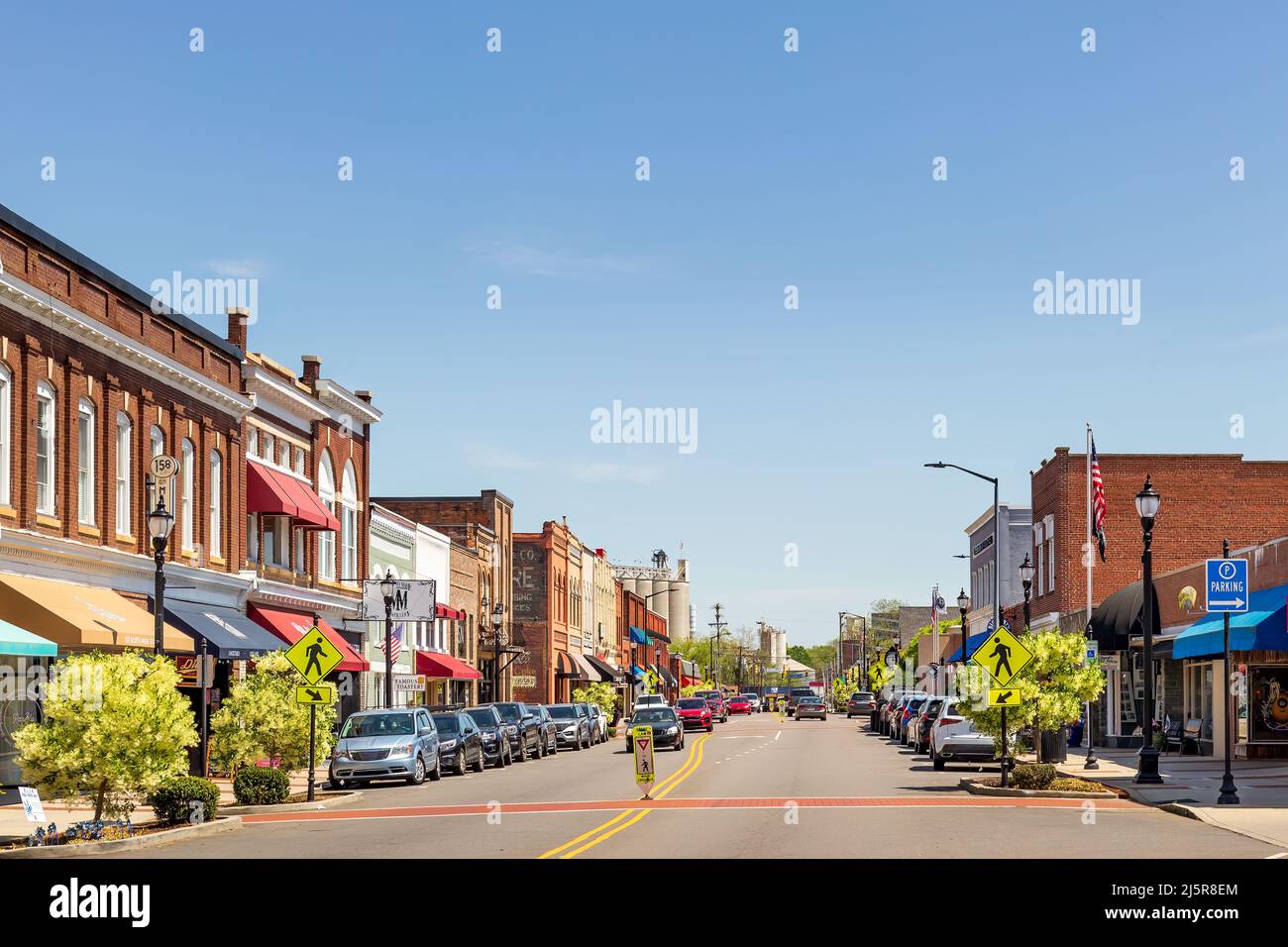 MOORESVILLE, NC, EE.UU.-17 DE ABRIL de 2022: Vista icónica y colorida de gran angular de la calle Main Street en un soleado cielo azul, día de primavera. Mirando hacia Bay State Milling Foto de stock