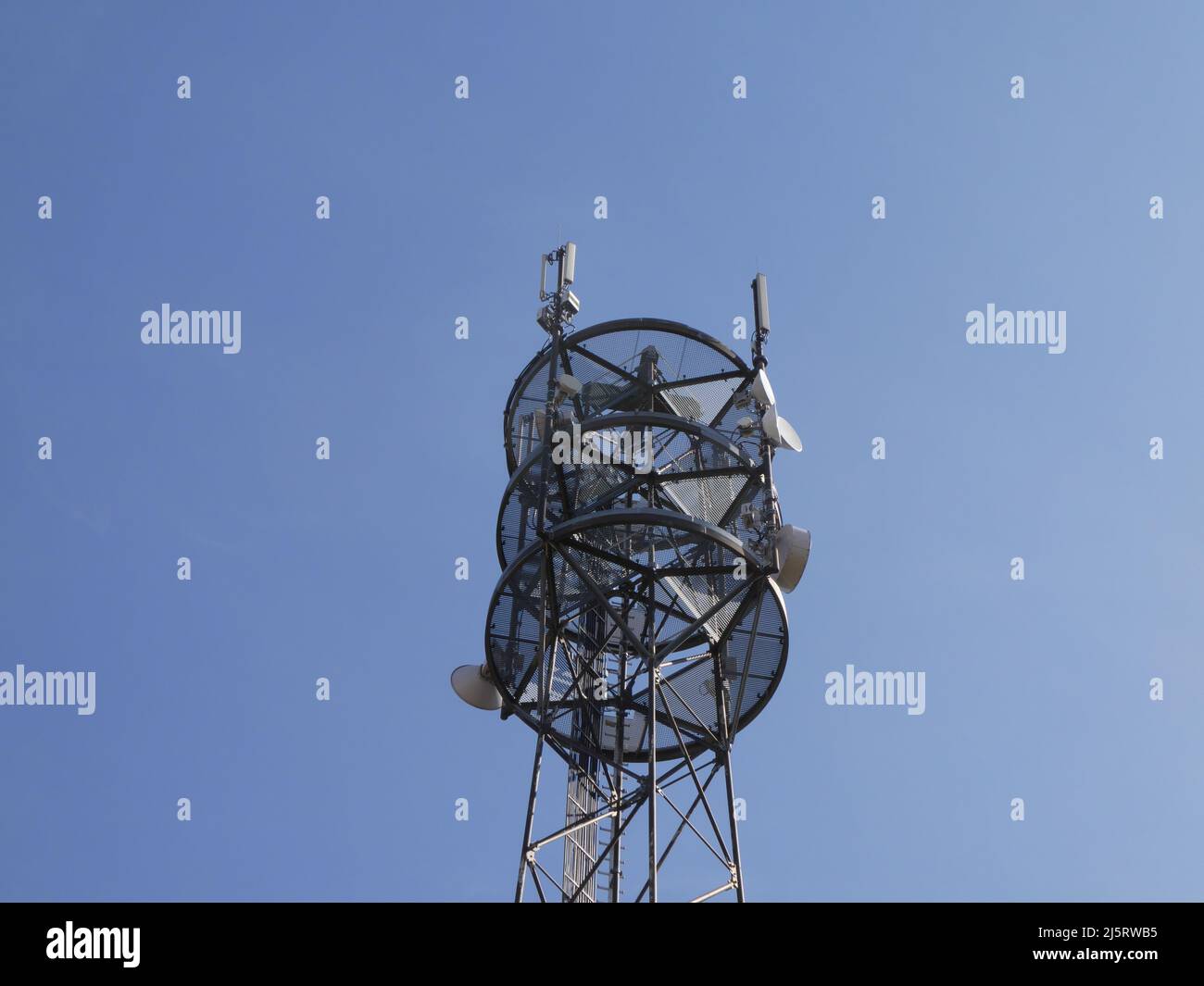 Mástil de celosía para la comunicación moblie contra el cielo azul Foto de stock