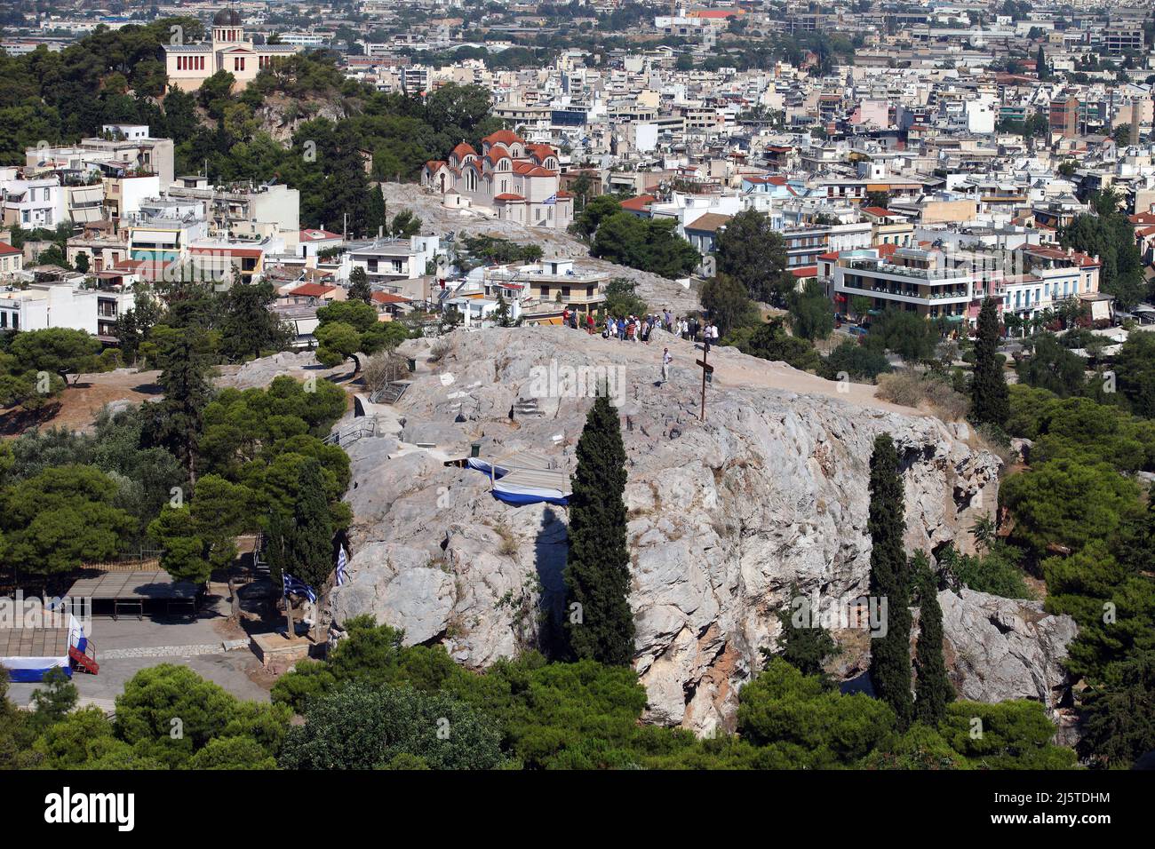 ATENAS, GRECIA - 29 DE JUNIO: Areópago (Mars Hill) detrás de la ciudad de Atenas desde la Acrópolis el 29 de junio de 2012 en Atenas, Grecia. Mars Hill es un lugar destacado ubicado a 140 pies por debajo de la Acrópolis. Foto de stock