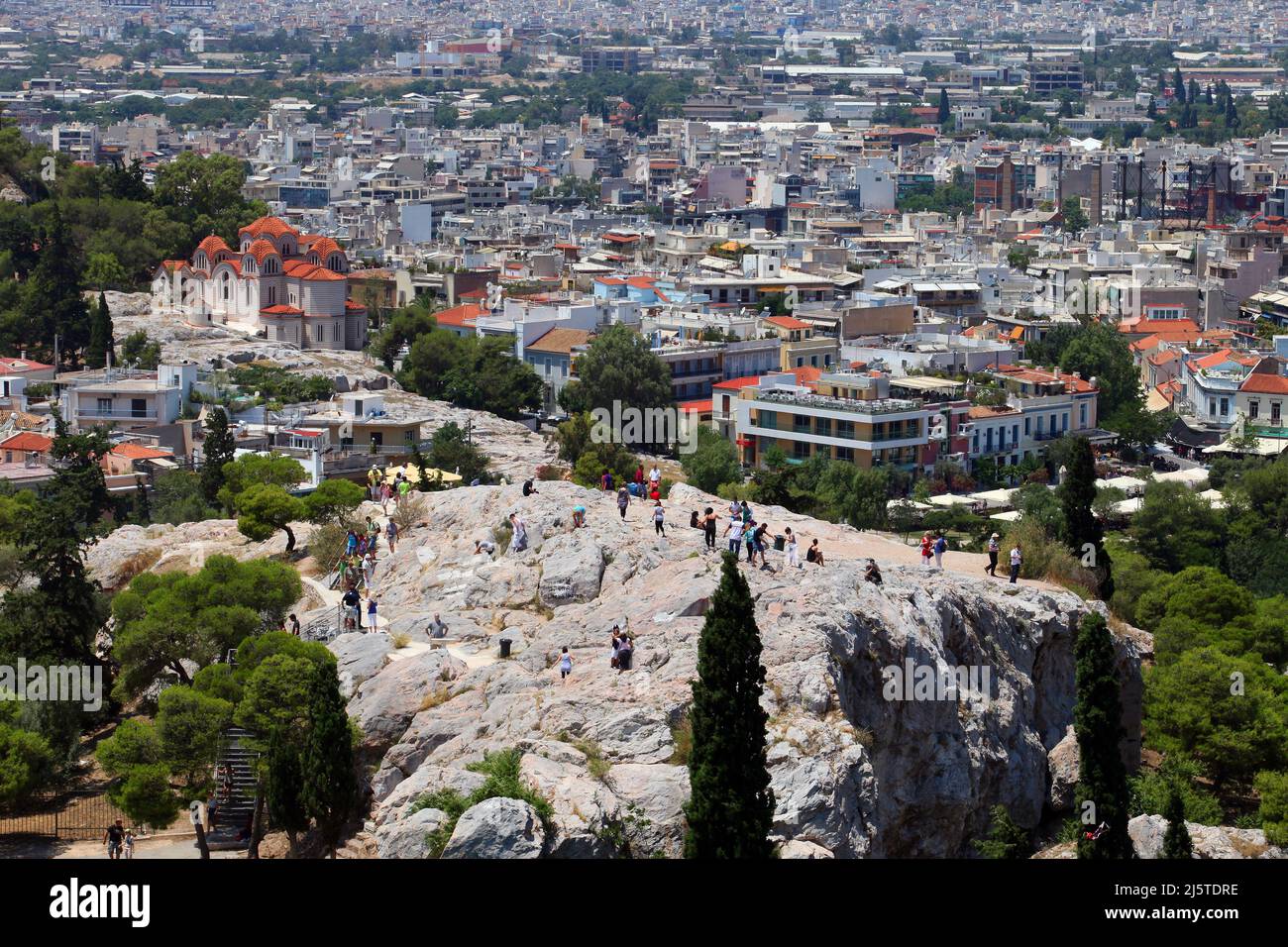 ATENAS, GRECIA - 29 DE JUNIO: Areópago (Mars Hill) detrás de la ciudad de Atenas desde la Acrópolis el 29 de junio de 2012 en Atenas, Grecia. Mars Hill es un lugar destacado ubicado a 140 pies por debajo de la Acrópolis. Foto de stock