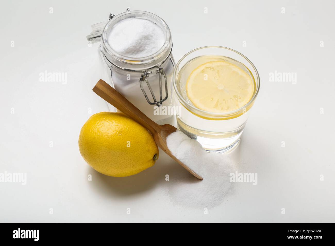Vaso de agua, tarro con bicarbonato de sodio y limón sobre fondo blanco  Fotografía de stock - Alamy