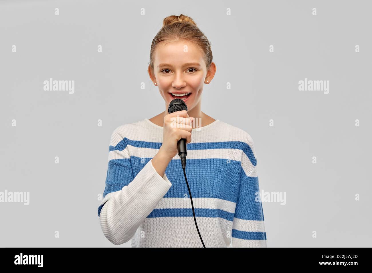 Niña cantando en un micrófono de juguete Fotografía de stock - Alamy