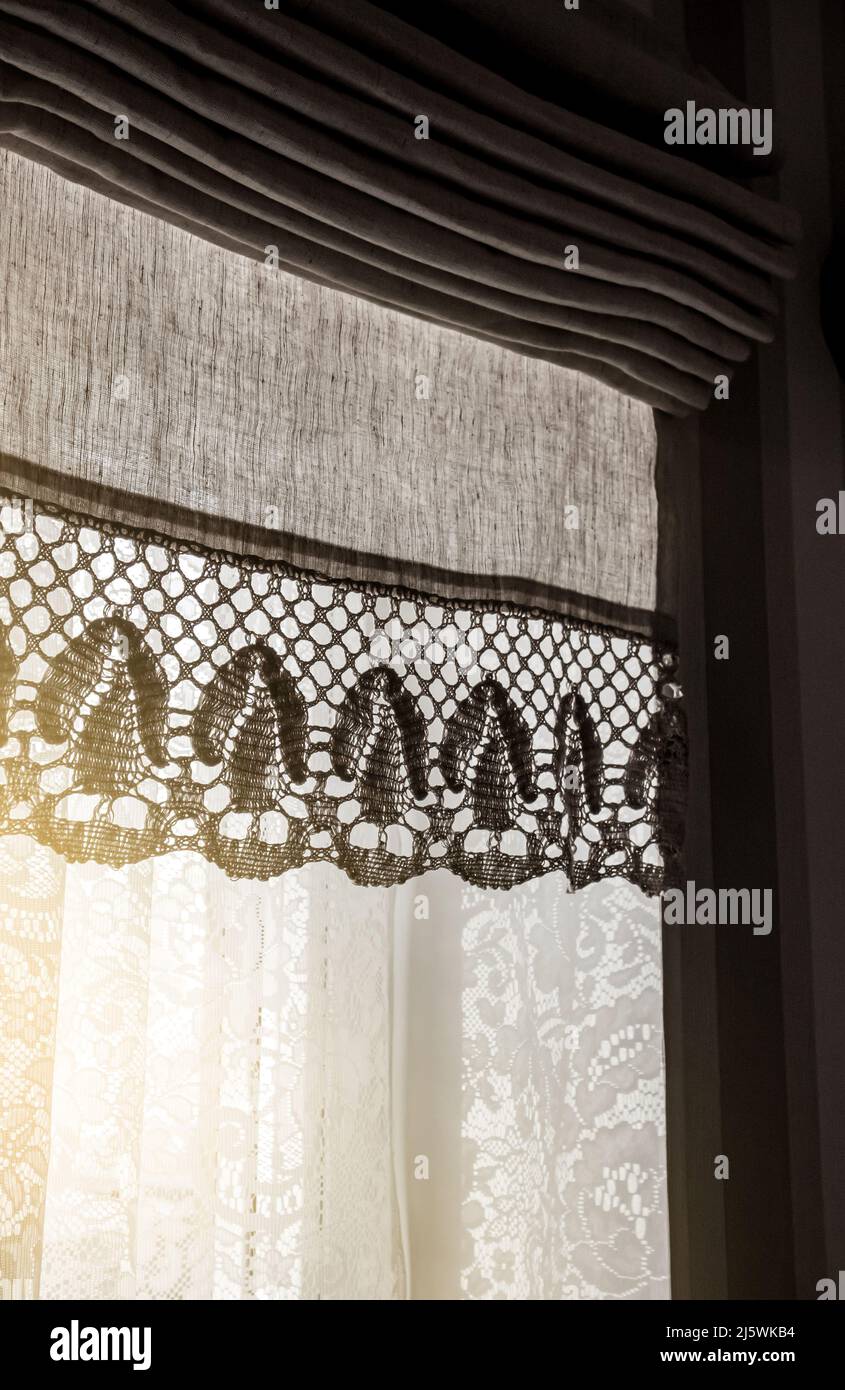 Cortina de lino llamada cortinas romanas en la ventana de la casa en el día soleado, en el interior. Foto de stock