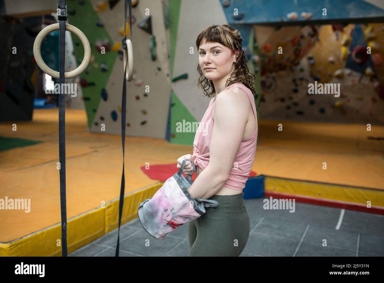 Retrato femenino seguro escalador de roca que tiña las manos Foto de stock
