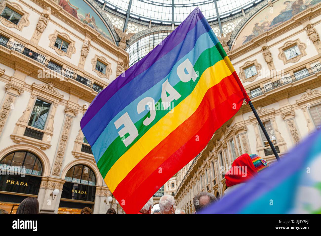 Un activista por la paz tiene una bandera arcoiris durante una manifestación pacifista contra el fascismo y la guerra entre Rusia y Ucrania. Bandera de la paz en Milán, Italia Foto de stock