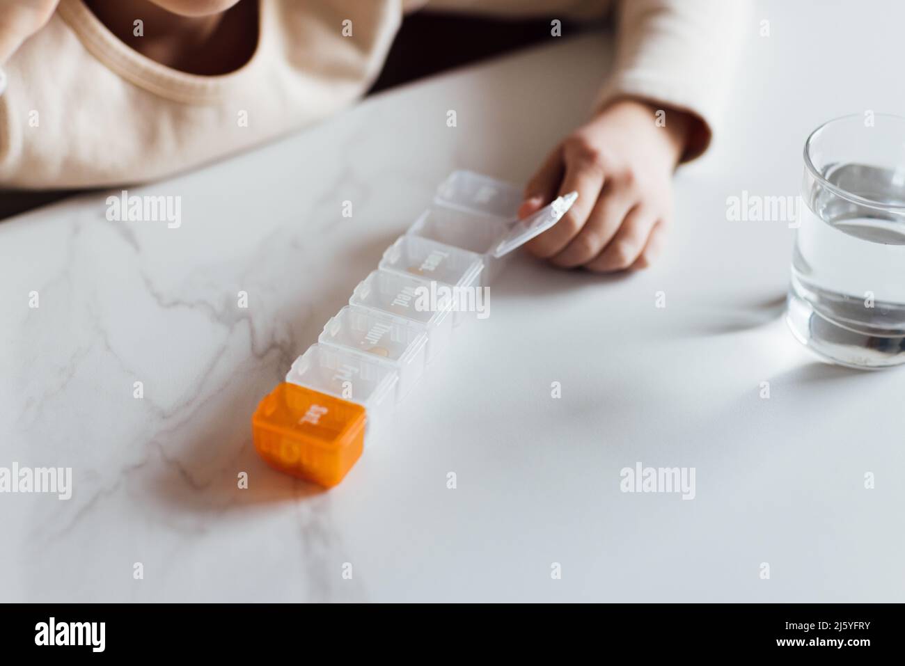 Niña Caucásica en pijamas tomando vitamina omega-3 natural de la caja de  plástico en la cocina en casa temprano por la mañana. Un niño adorable toma  suplementos Fotografía de stock - Alamy