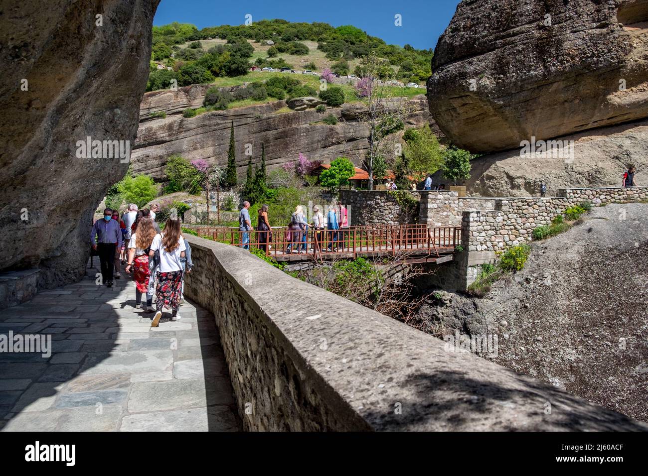 La gente que sube escaleras cortó en una roca y un puente a Varlaam (Agioi Pantes) Monasterio Meteora , Grecia Foto de stock