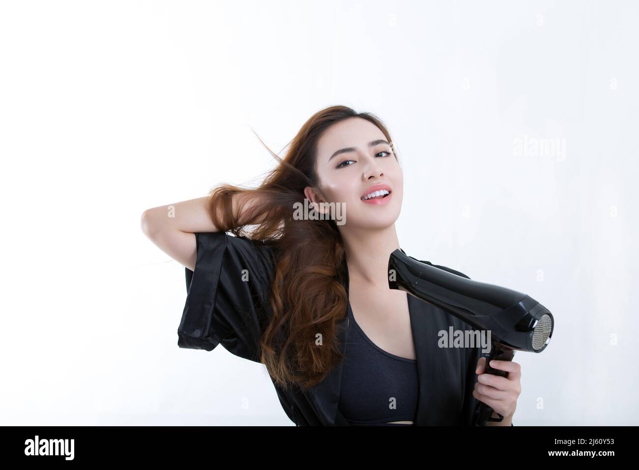 Joven y hermosa mujer china que utiliza un secador de pelo para secar el  cabello, sobre fondo blanco - foto de stock Fotografía de stock - Alamy