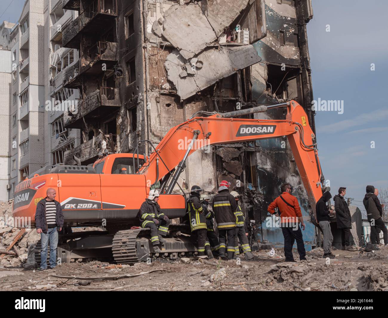 Borodyanka, Ucrania - 2022 de abril: Equipo de rescate está buscando personas muertas bajo los escombros. Búsqueda de obras de personas afectadas en las ruinas de un edificio de apartamentos. Casas bombardeadas de civiles en Ucrania Foto de stock