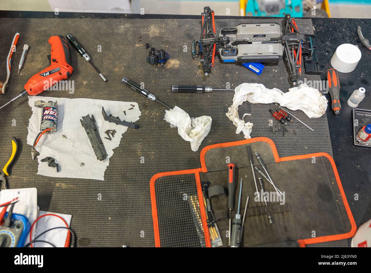 Vista de cerca de la mesa de trabajo con conjunto de herramientas y piezas de repuesto para la reparación de coches de juguete controlados por radio. SUECIA. Foto de stock