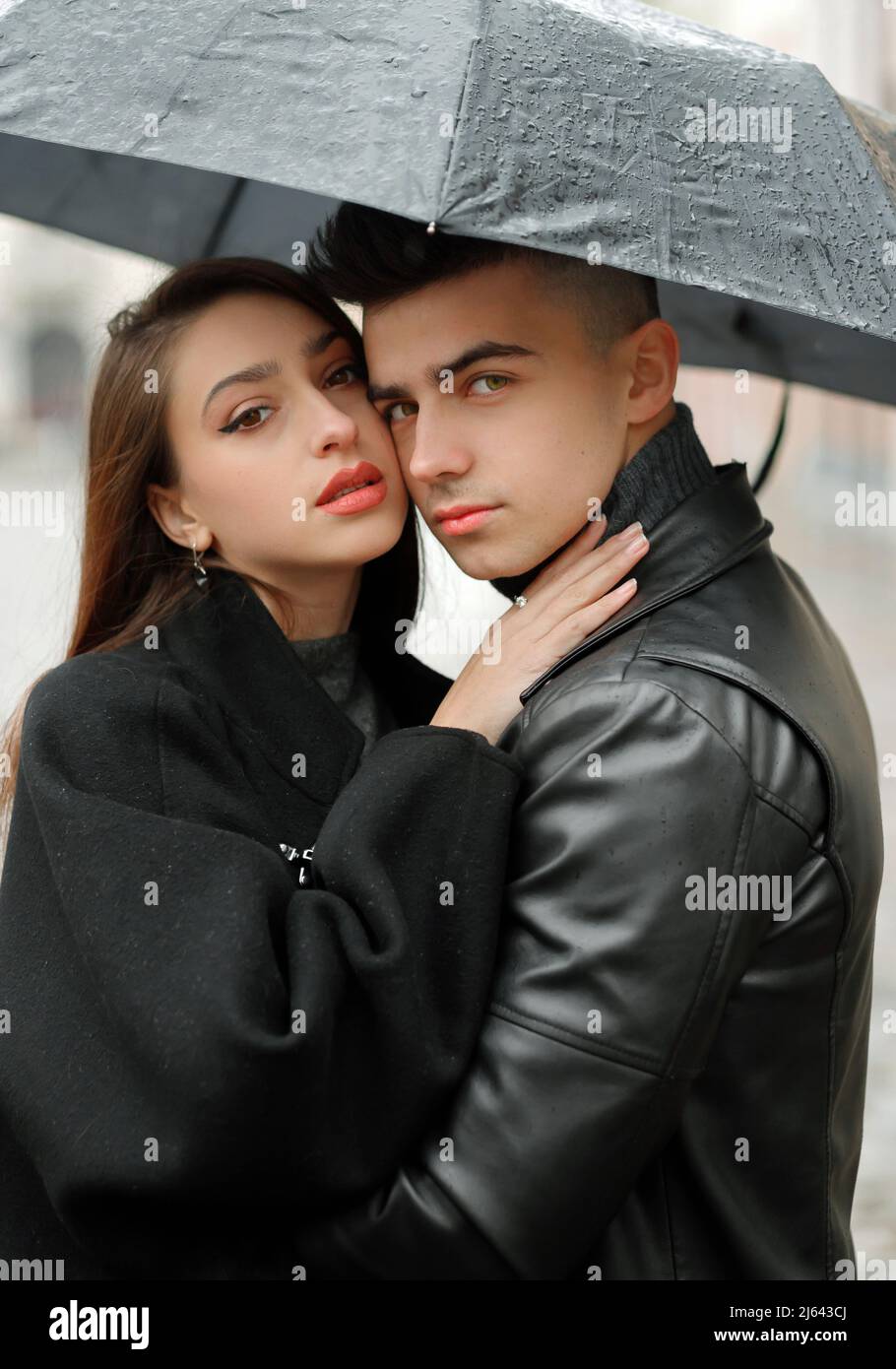 Dulce pareja niño y niña abrazando bajo un paraguas bajo la lluvia. El  concepto de amor, romance y pasión Fotografía de stock - Alamy