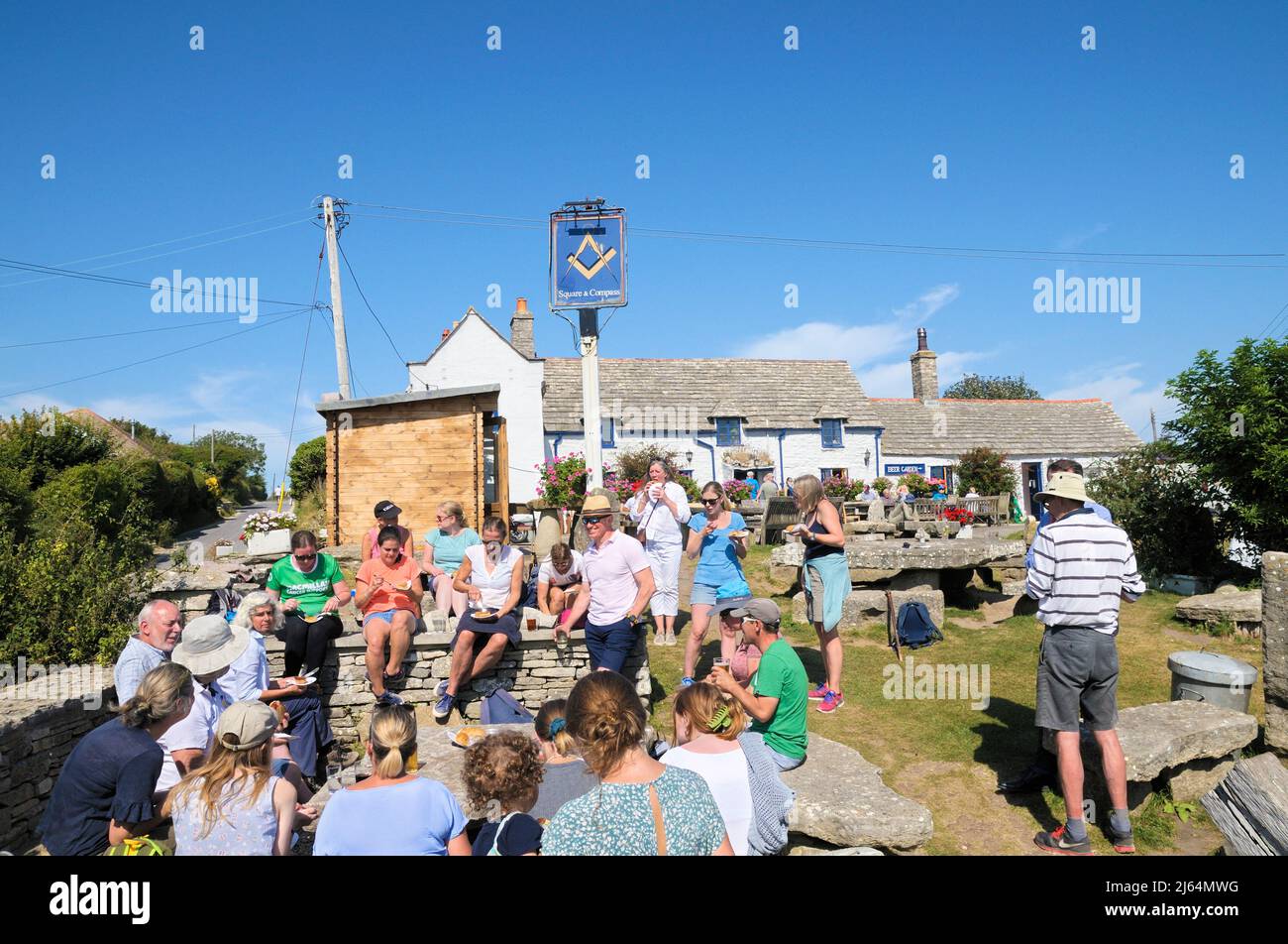 Gente disfrutando de la comida y bebida en The Square and Compass, un galardonado pub en el pueblo de Worth Matravers, Isla de Purbeck, Dorset, Inglaterra, Reino Unido Foto de stock