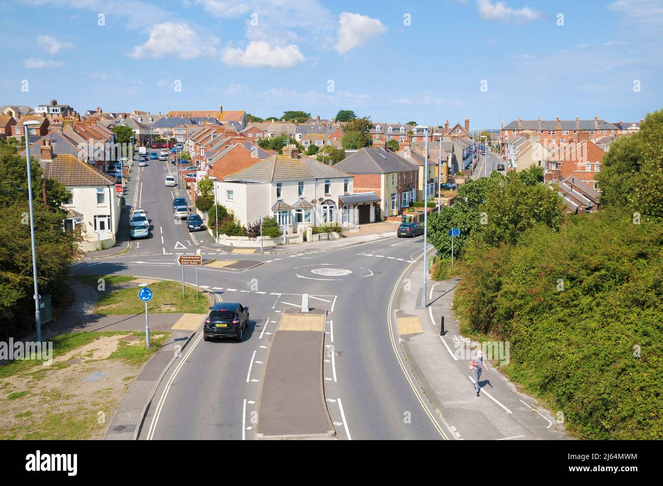 Vista elevada de calles residenciales y casas adosadas con mini-rotonda y cruce de carreteras en las afueras de Weymouth, Dorset, Inglaterra, Reino Unido Foto de stock