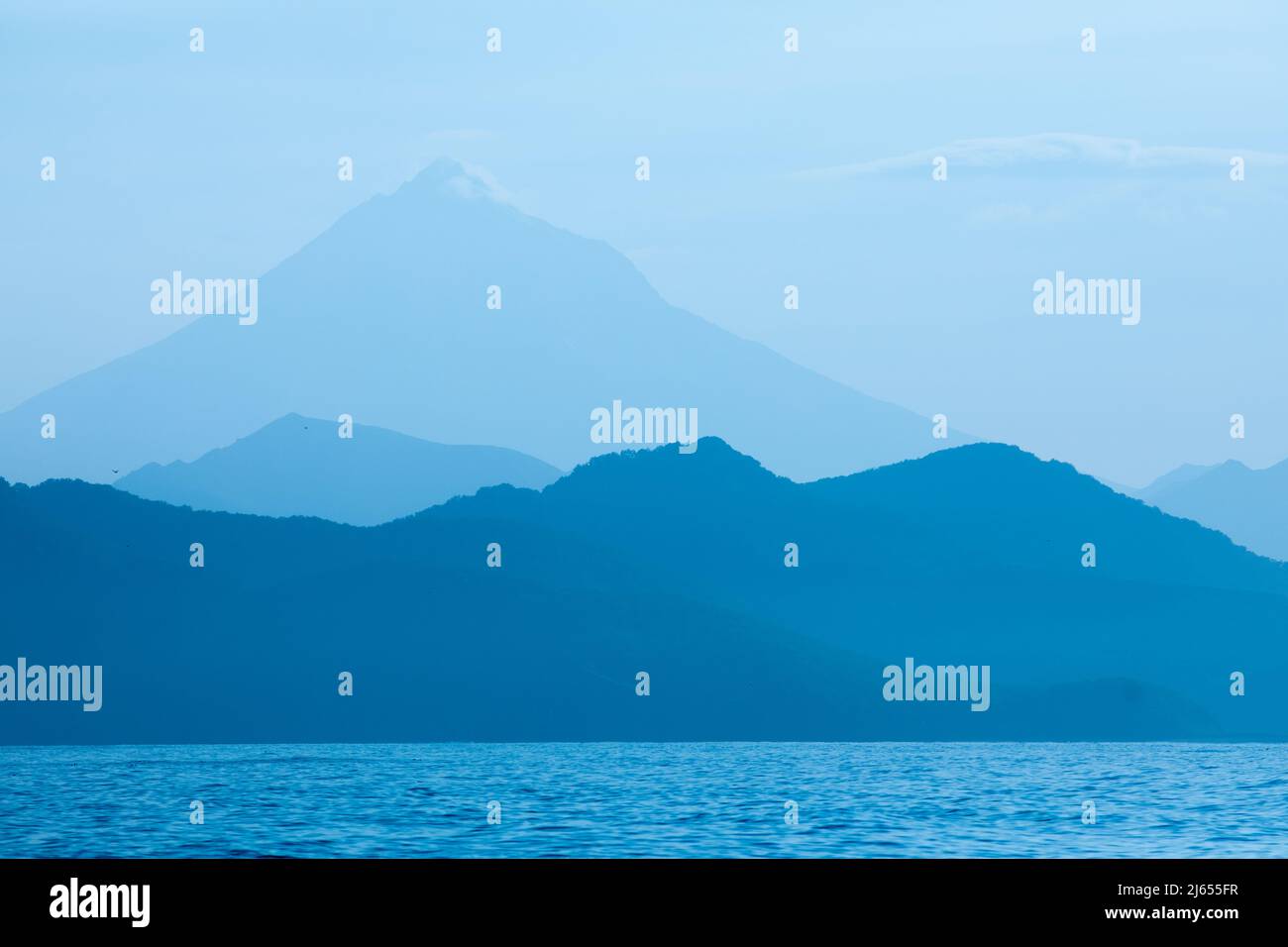 Montañas azules y mar natural Kamchatka paisaje de fondo Foto de stock