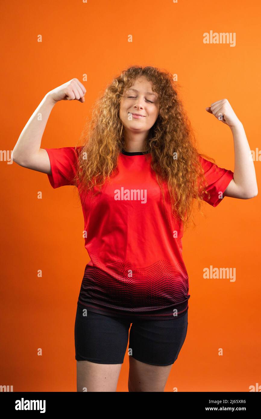 Imagen de una mujer fuerte con ojos cerrados con un color uniforme rojo- negro de su equipo de fútbol favorito y pensando en la victoria Fotografía  de stock - Alamy