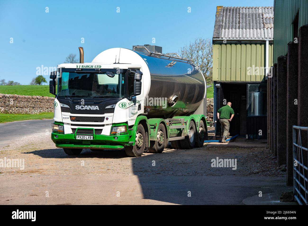 Un camión de leche recolectando leche de una granja lechera, Cumbria, Reino Unido. Foto de stock