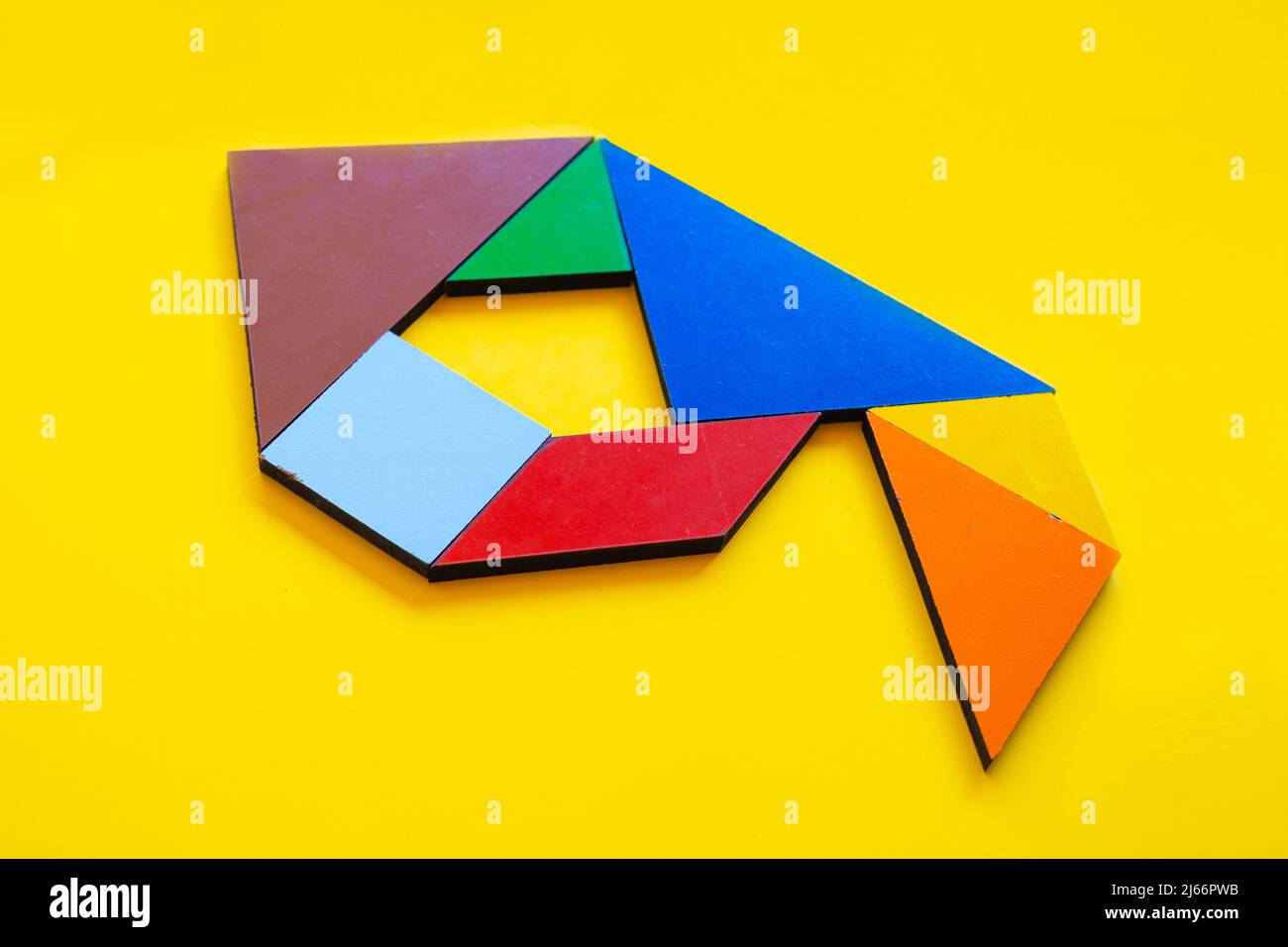 Colorido número 9 hecho con juguete tangram, tangram color número siete aislado sobre fondo amarillo, vista lateral de séptimo numérico, idea de juego para niños Foto de stock