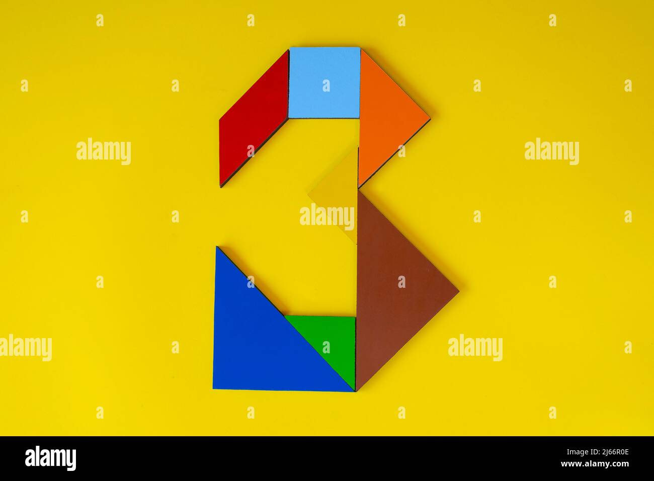 Colorido número 3 hecho con juguete tangram, tangram color número siete aislado sobre fondo amarillo, vista lateral de séptimo numérico, idea de juego para niños Foto de stock