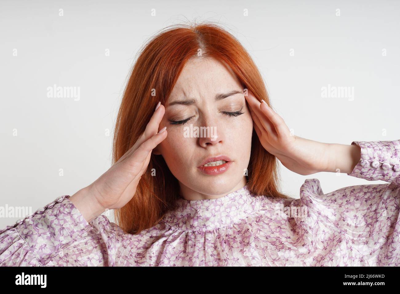 mujer que sufre de dolor de cabeza o migraña masajeando sus templos para aliviar el dolor Foto de stock