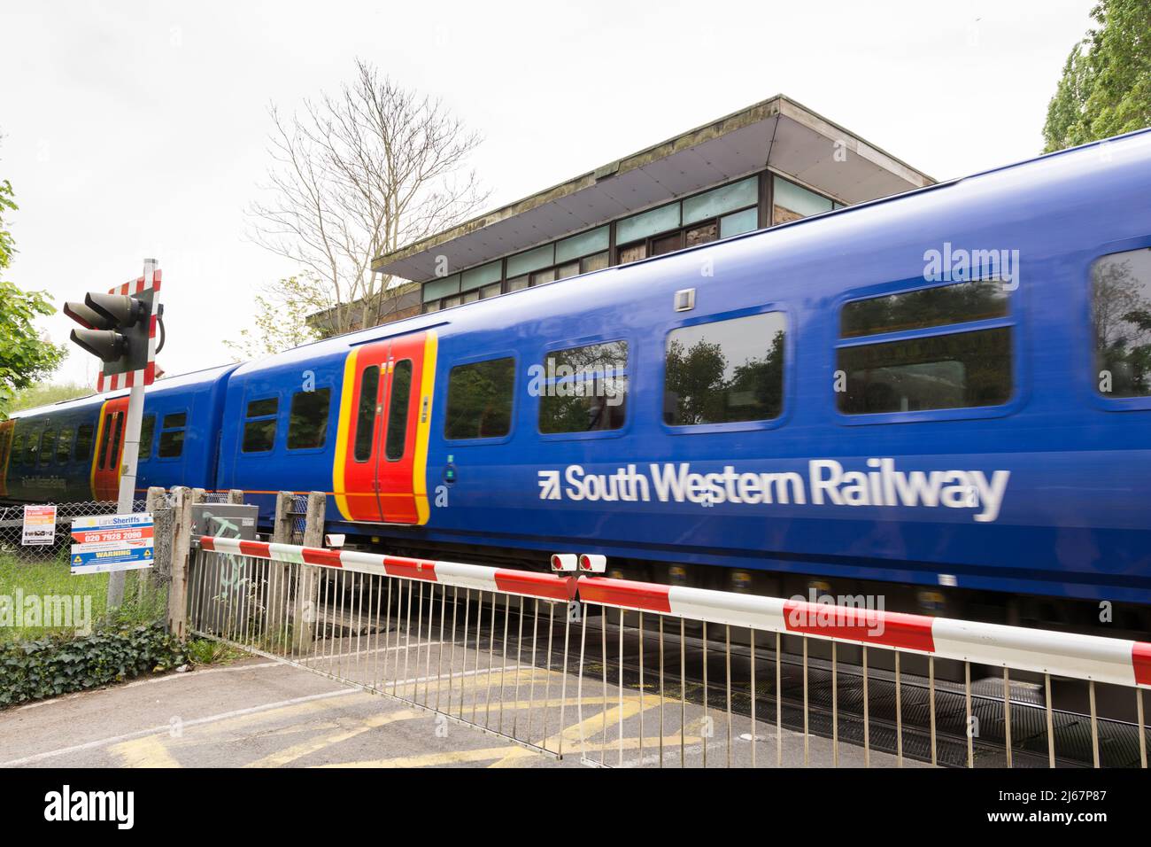 Un tren South Western Railway que pasa por Vine Road cruce la señal de la caja, Barnes, Londres, SW13, Inglaterra, REINO UNIDO Foto de stock