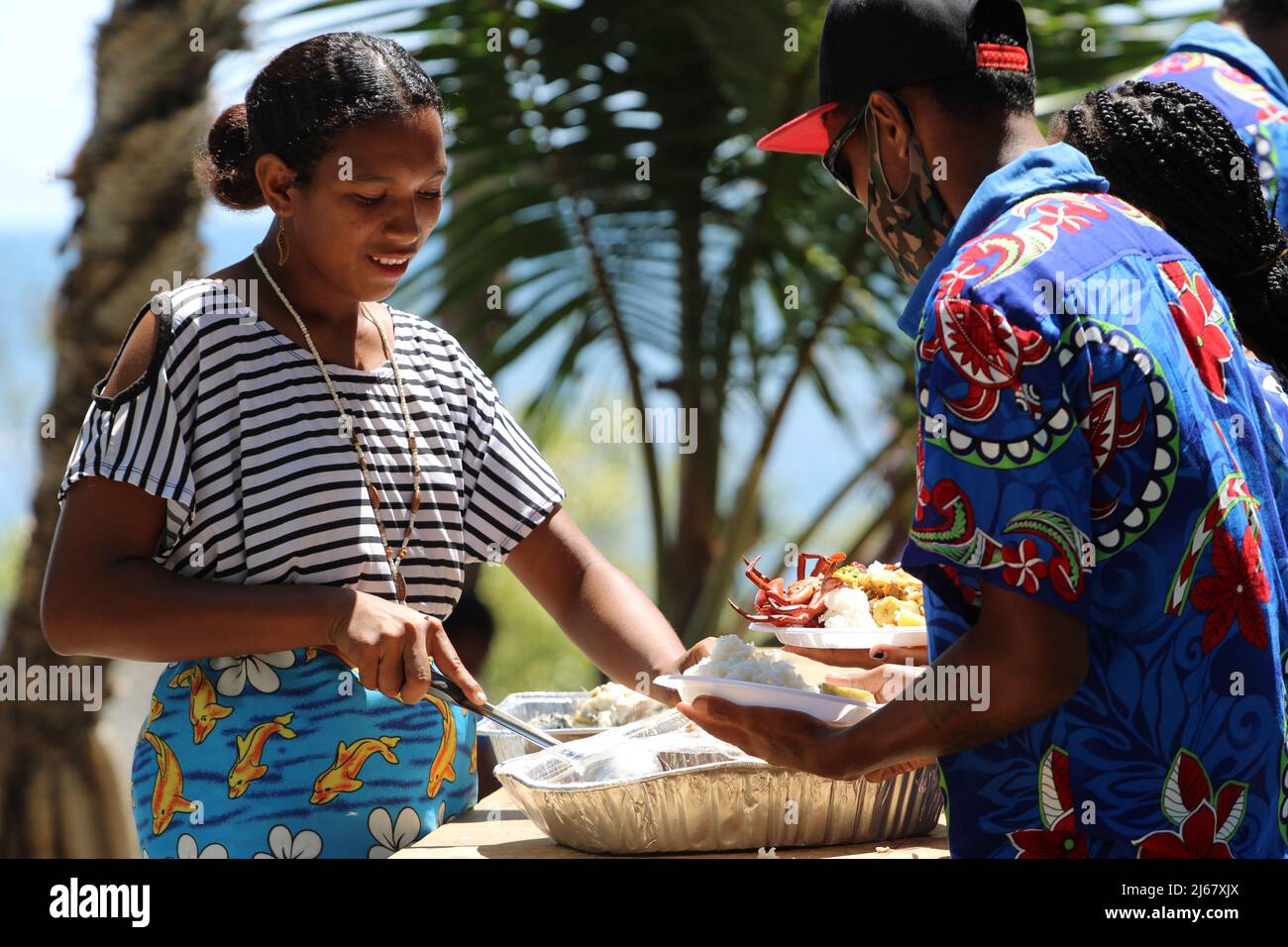 Una joven mujer Central atendiendo a los huéspedes en una boda en 2021 en la aldea de Papa, Papua Nueva Guinea. Foto de stock